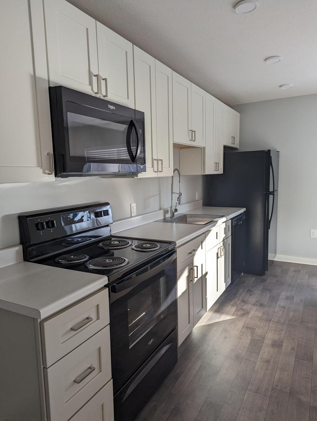 a kitchen with black appliances and white cabinets