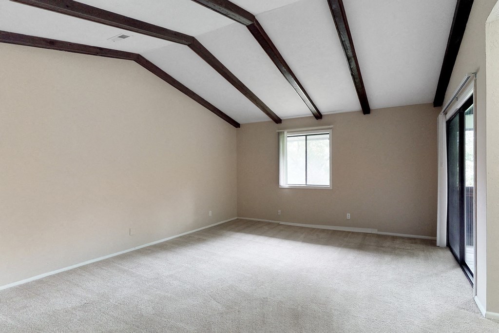 an empty living room with exposed beams on the ceiling