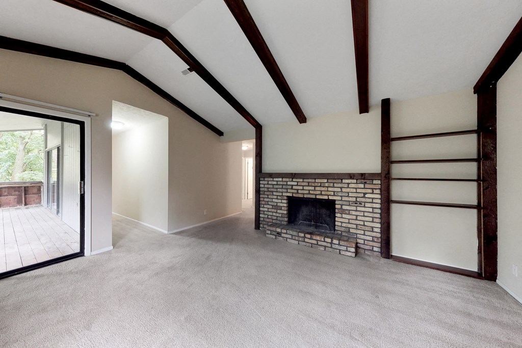 an empty living room with a fireplace and a sliding glass door