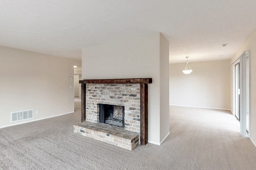 a living room with a fireplace and a carpeted floor