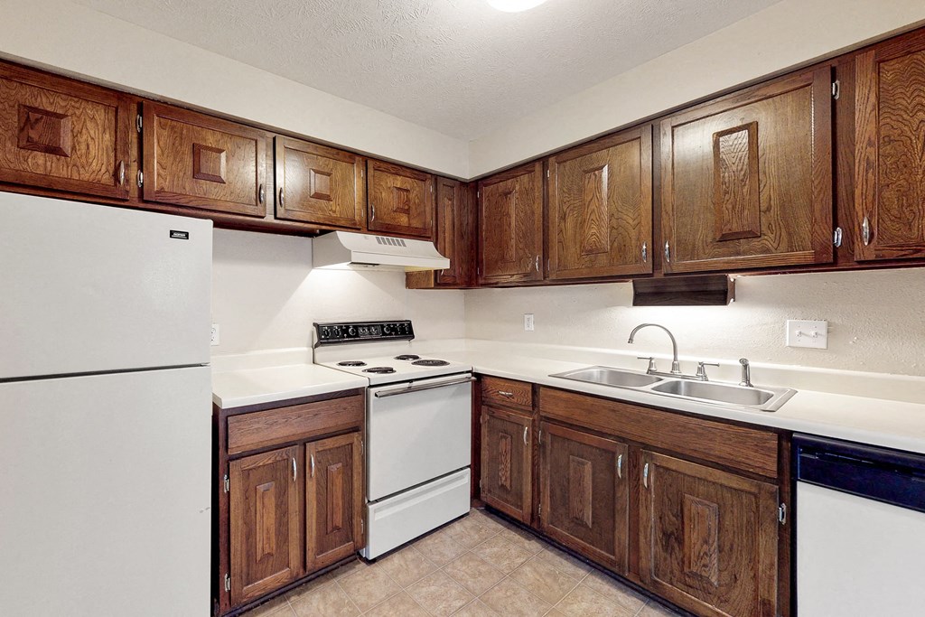 a kitchen with white appliances and wooden cabinets