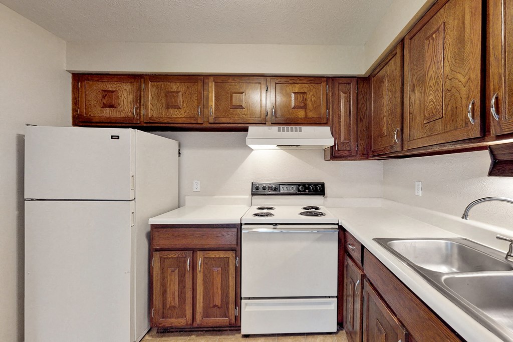 a kitchen with white appliances and wooden cabinets