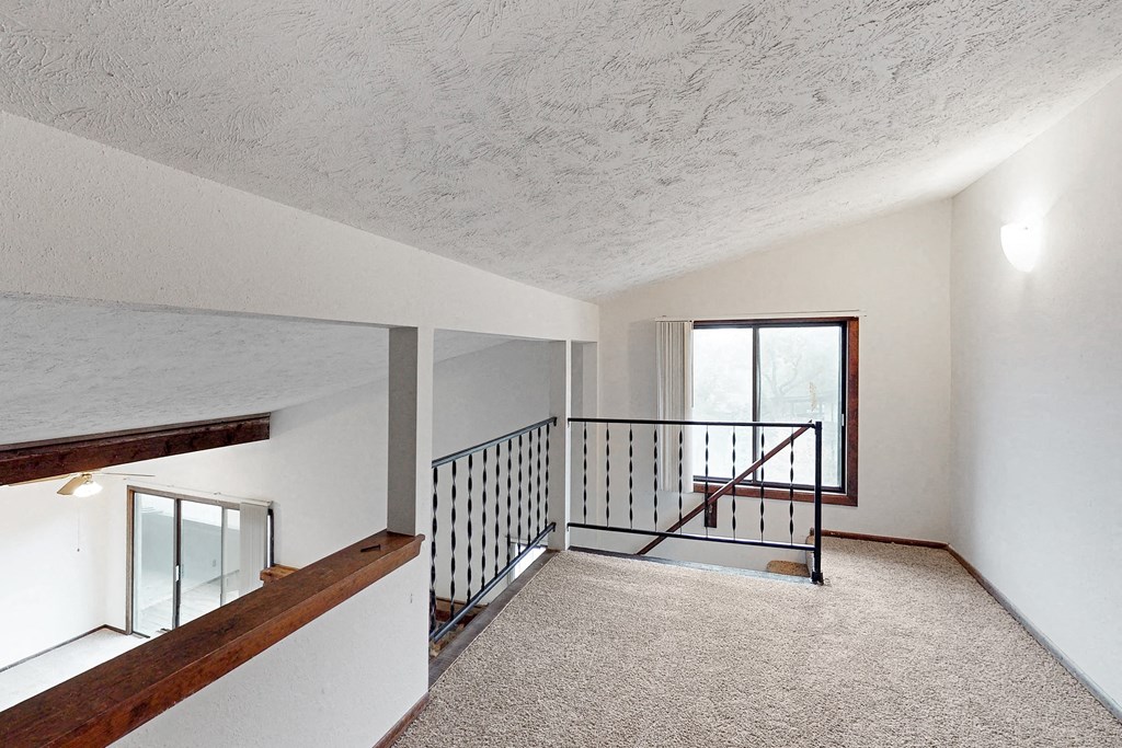 a view of the top of a staircase in a home with carpeted floors