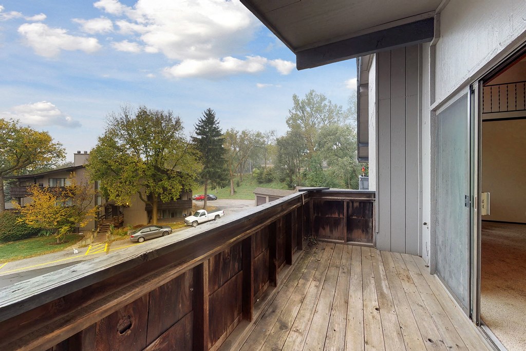 a balcony with a wooden deck and a window