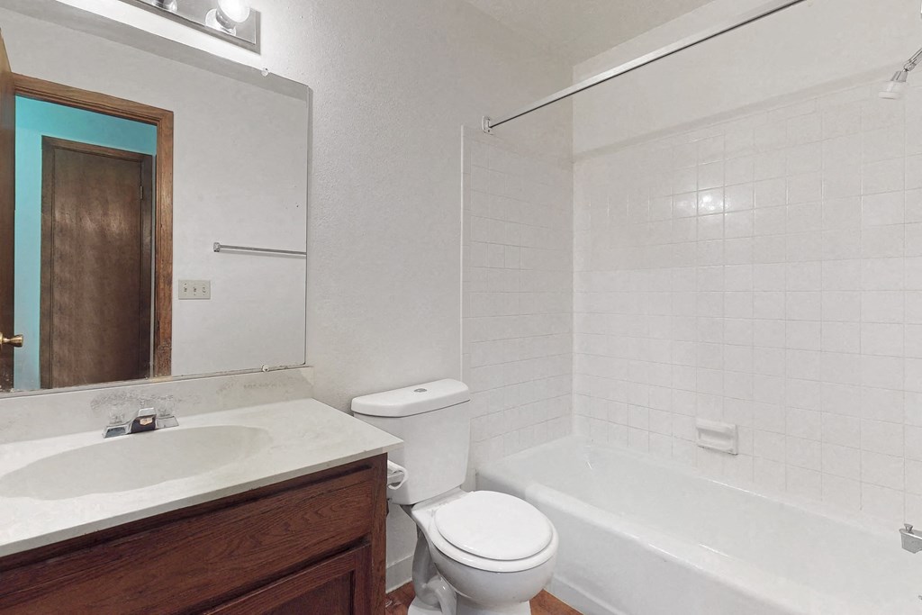 a bathroom with a toilet sink and tub and a mirror