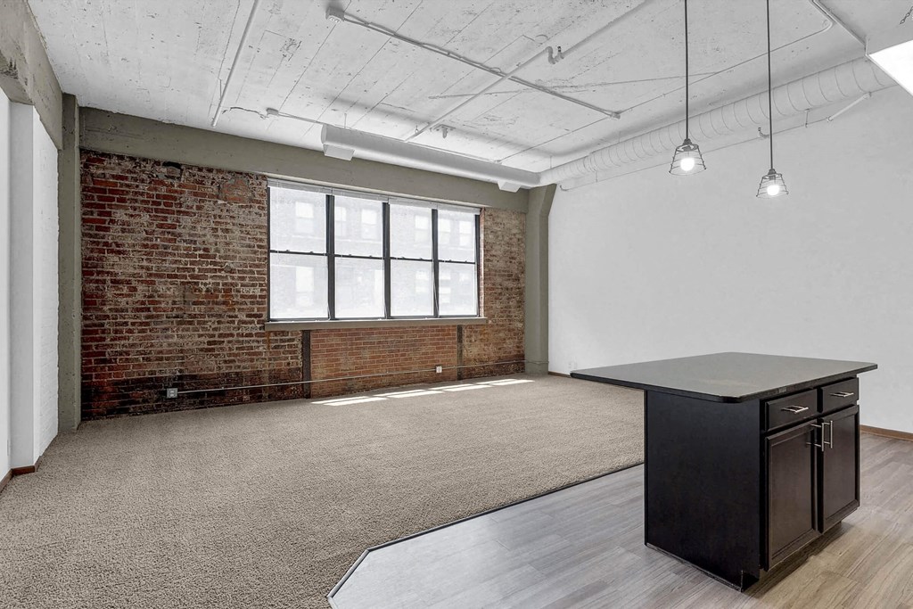 an empty room with a table and a brick wall