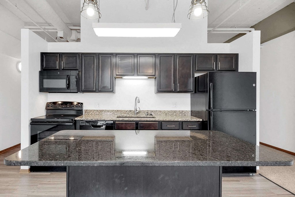 a kitchen with black appliances and granite counter tops