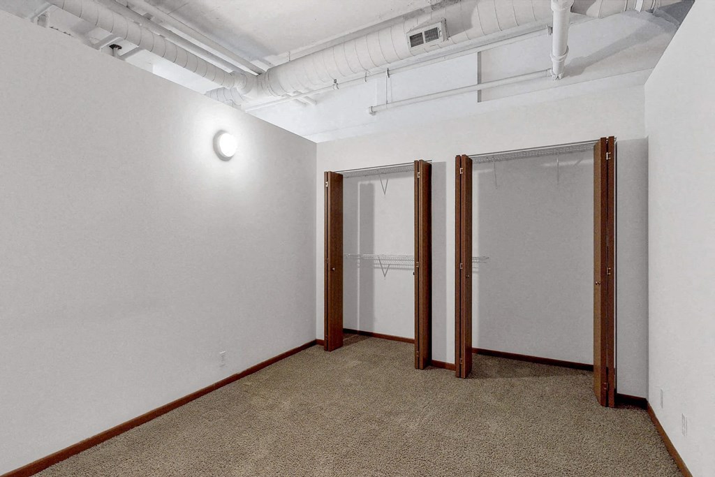 a room with white walls and three doors