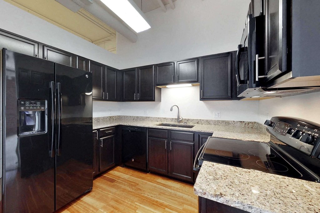 a kitchen with black appliances and granite counter tops