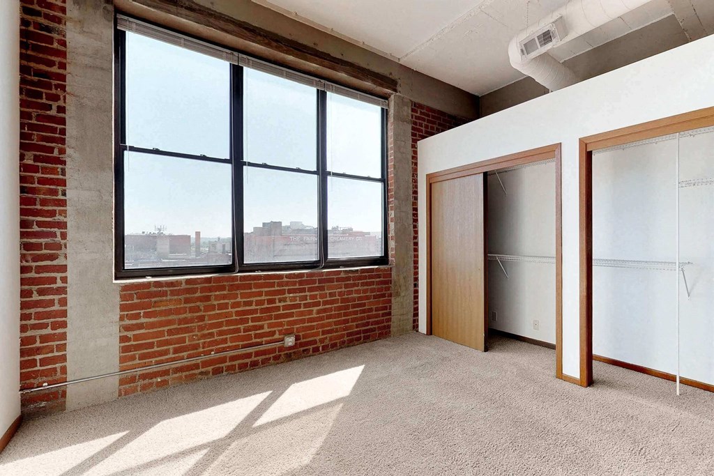 an empty room with a brick wall and two doors