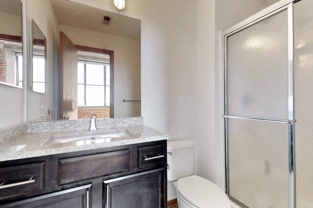 a bathroom with a sink and a shower and a toilet