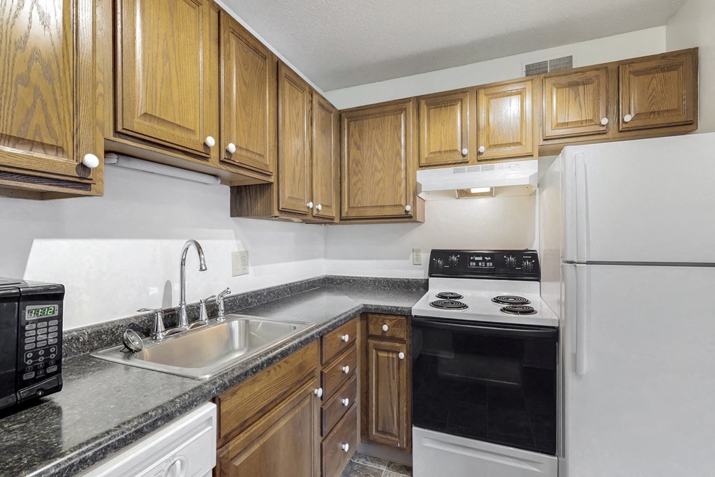 a kitchen with white appliances and wooden cabinets
