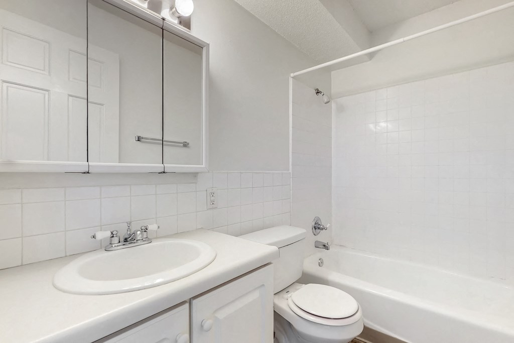 a white bathroom with a sink toilet and tub