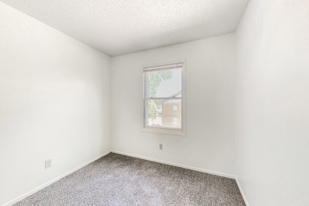 an empty room with carpet and a window