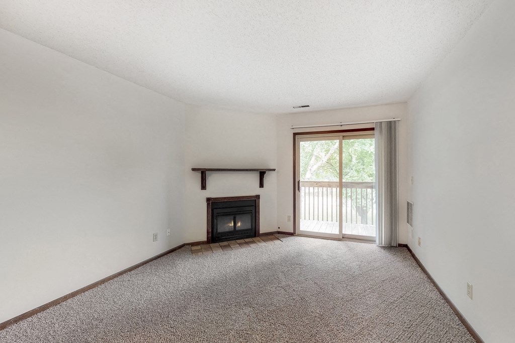 an empty living room with a fireplace and a window