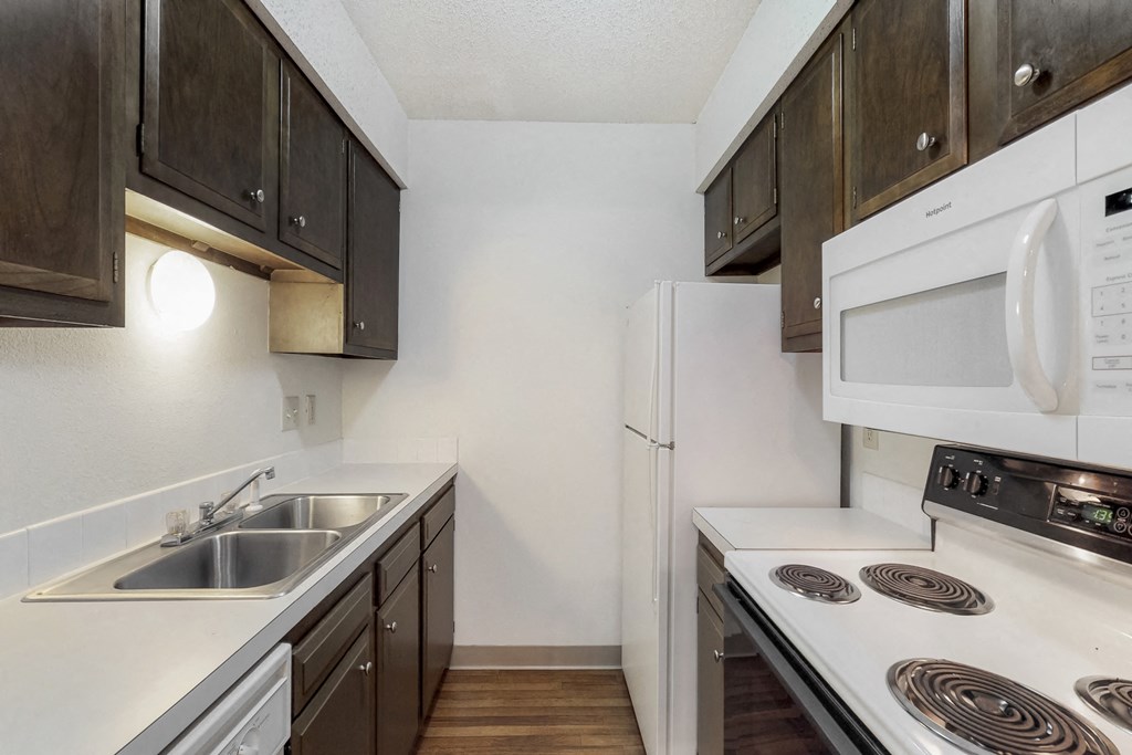 the preserve at ballantyne commons apartment kitchen with white appliances and dark cabinets