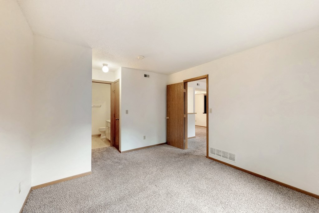 a renovated living room with white walls and a carpeted floor