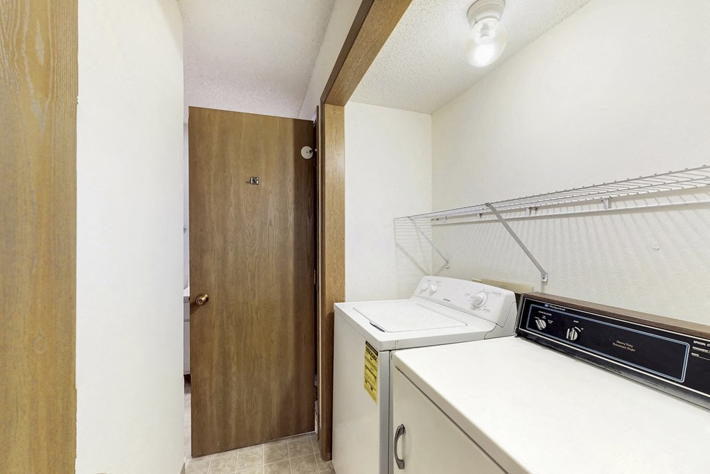 a laundry room with a washer and dryer and a door to a closet
