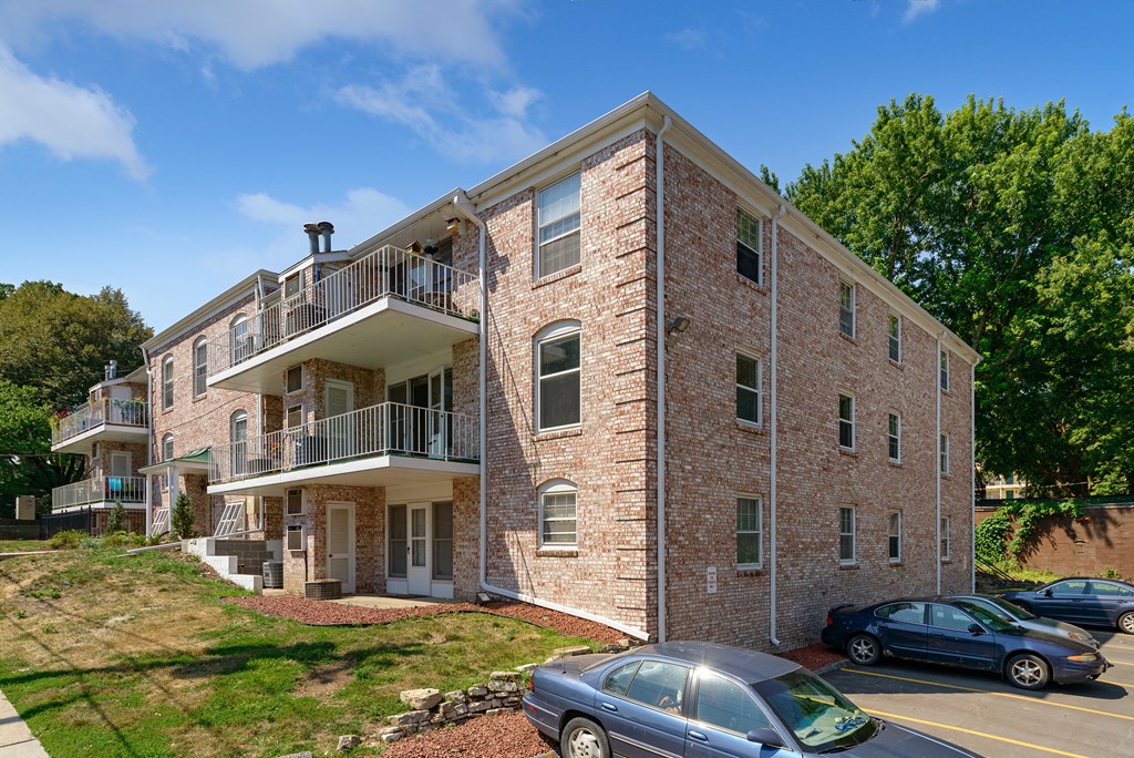 a brick apartment building with cars parked outside