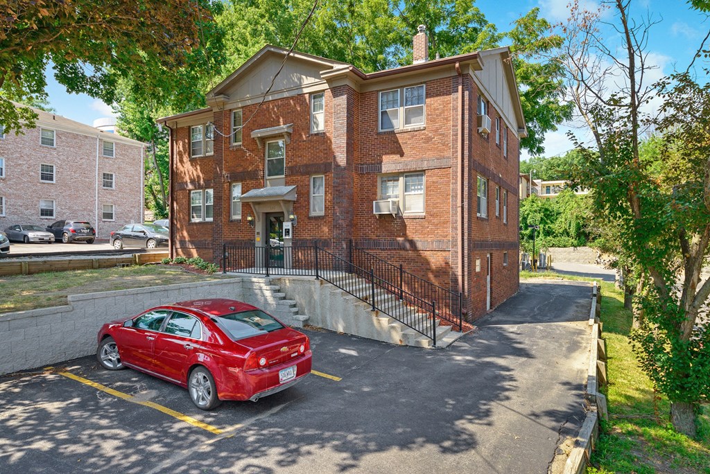 a red brick house with a red car parked in front of it