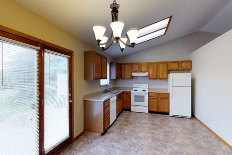 A kitchen with wooden cabinets and white appliances.