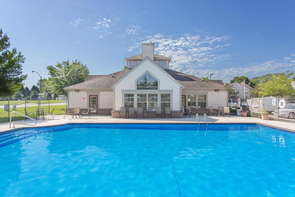 a swimming pool with a house in the background