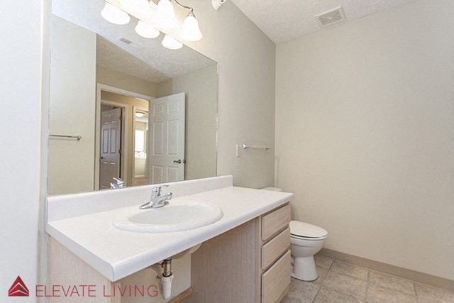 a bathroom with a sink and a toilet and a mirror