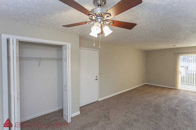 a bedroom with a ceiling fan and a closet