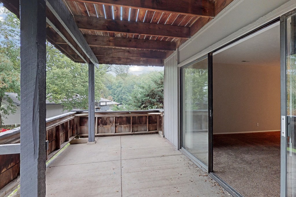 a covered porch with sliding glass doors and a deck