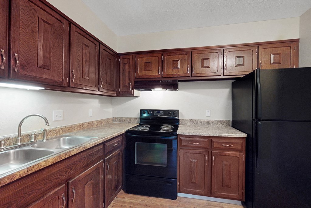 a kitchen with wooden cabinets and black appliances
