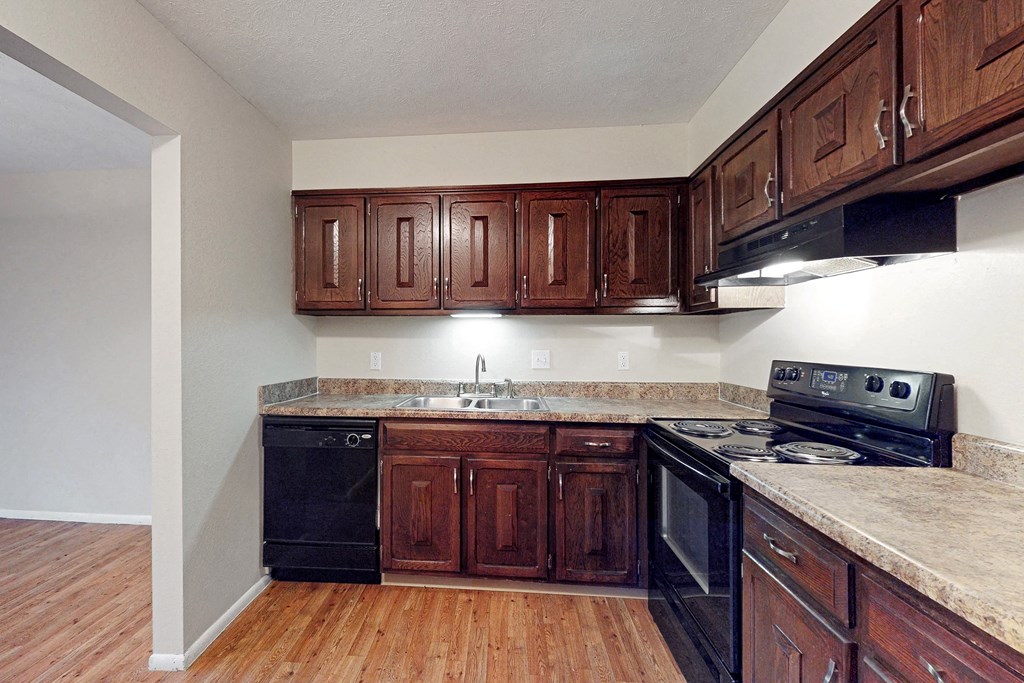 a kitchen with wooden cabinets and black appliances