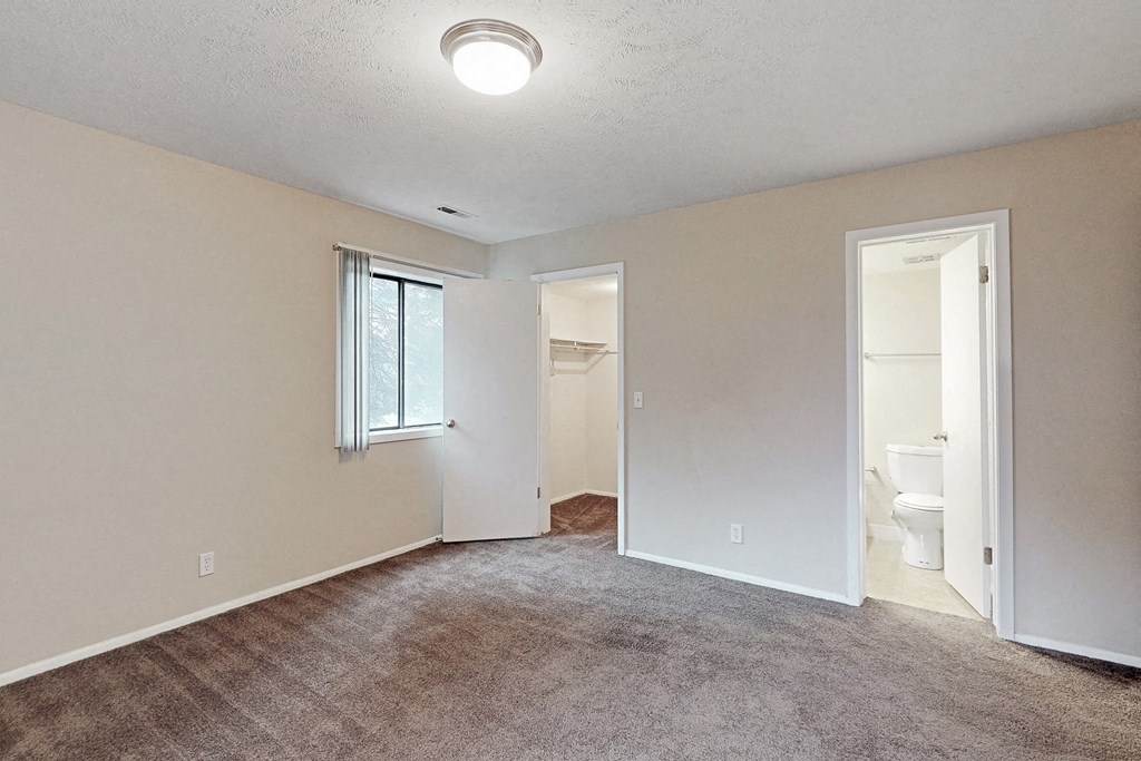 an empty living room with a door leading to a bathroom