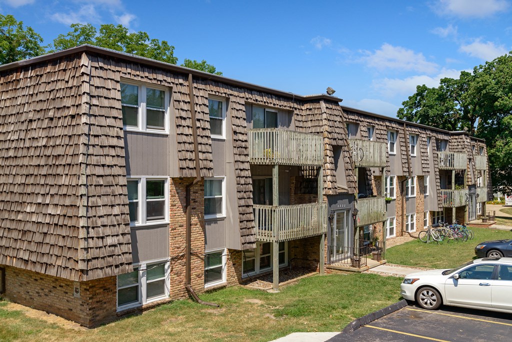 an apartment building with balconies and a car parked in front