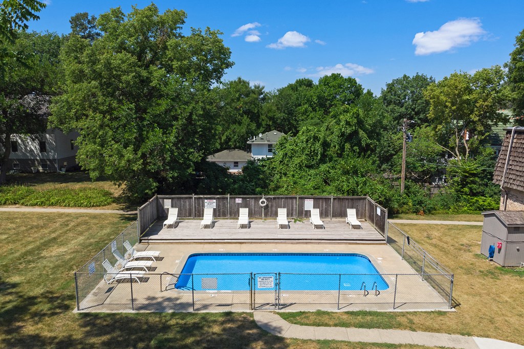 the pool is in the backyard of a house with a fence around it