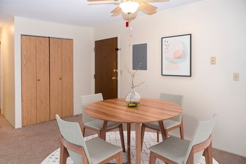 A dining room with a round table and chairs.