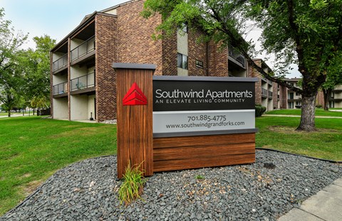 A sign for Southwind Apartments stands in front of a brick building.