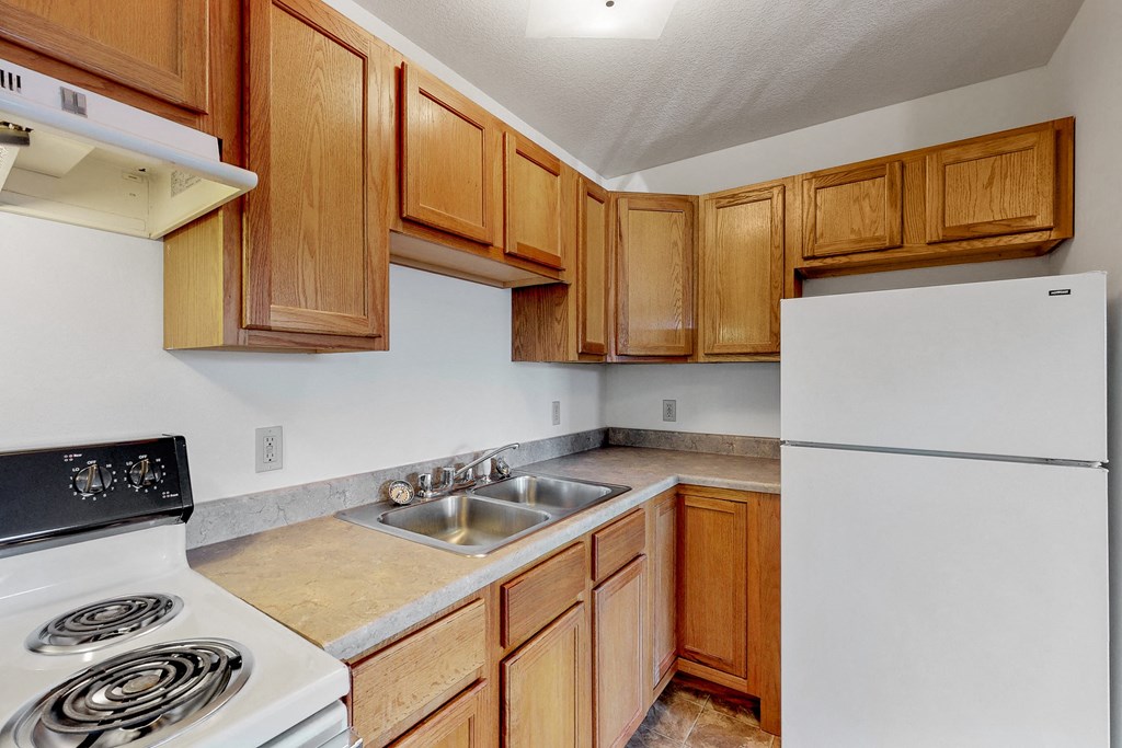 a kitchen with white appliances and wooden cabinets