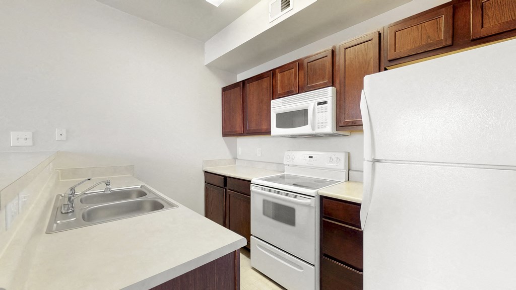 a kitchen with white appliances and wooden cabinets