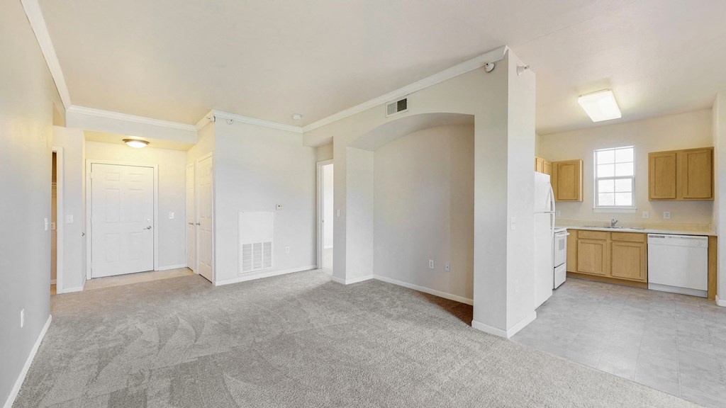 the spacious living room and kitchen in a new home