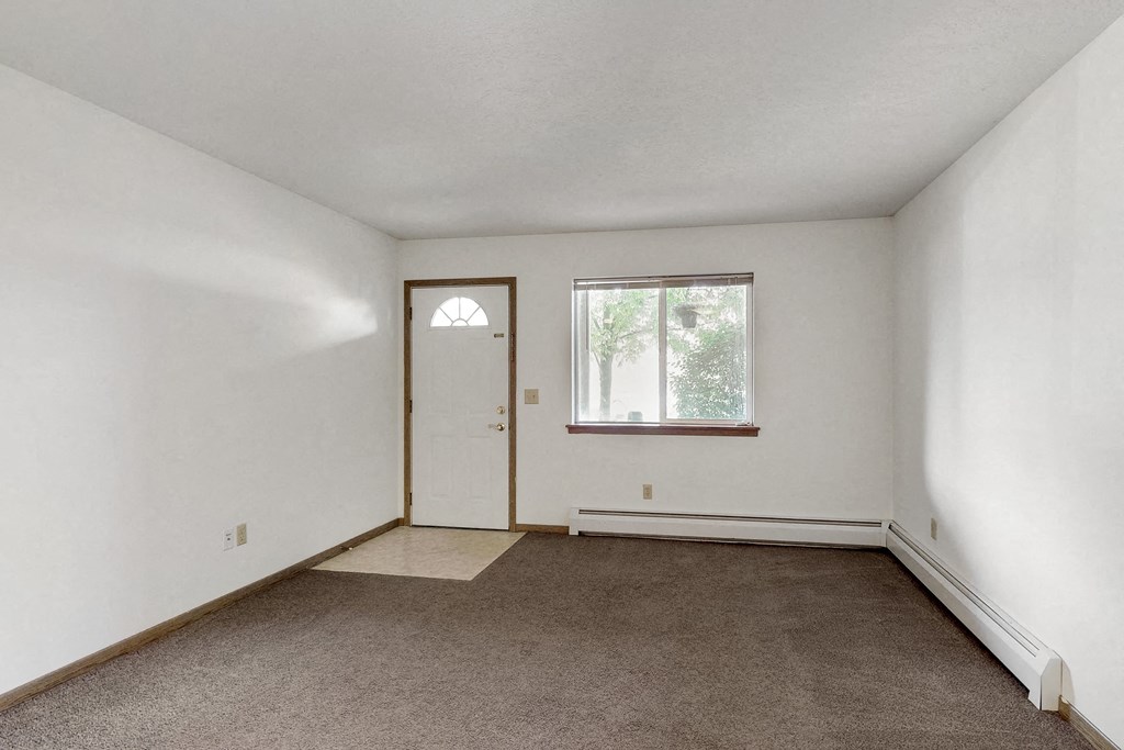 an empty room with a door and a window