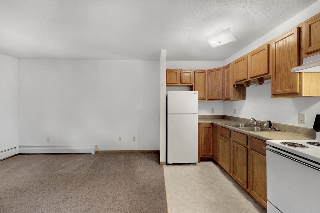 a kitchen with white appliances and wooden cabinets