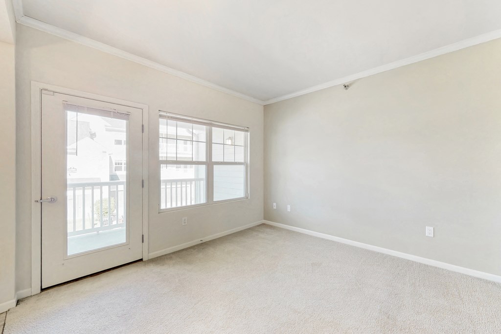the living room of an empty home with white walls and doors