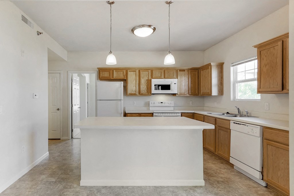 an empty kitchen with an island in the middle
