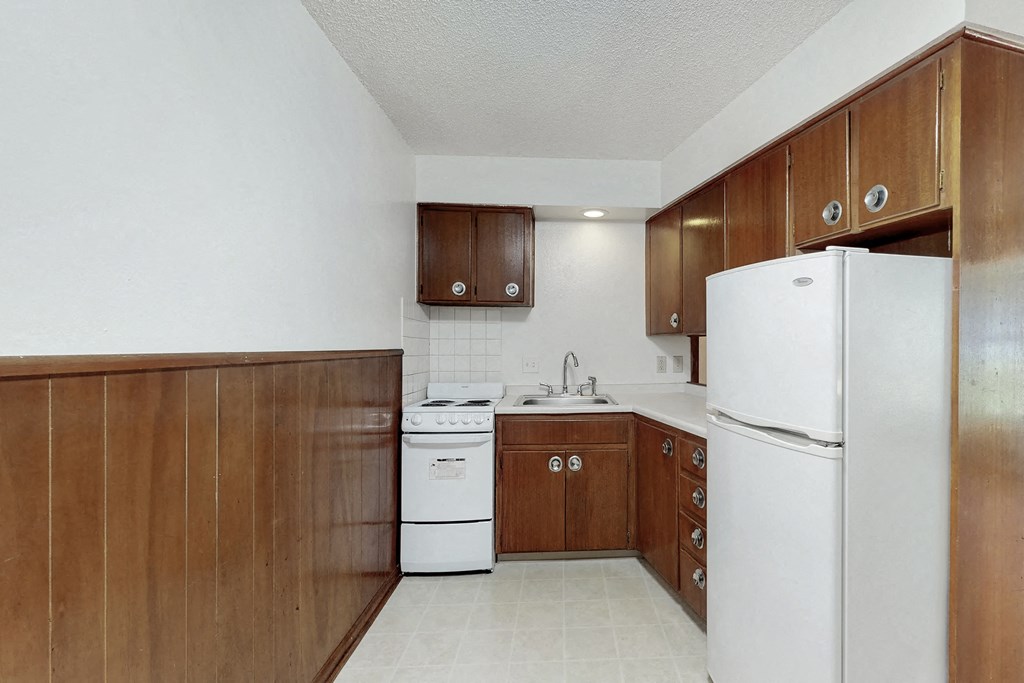 a kitchen with white appliances and wooden cabinets