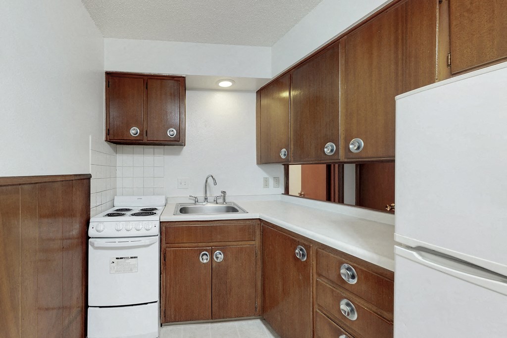 a kitchen with white appliances and wooden cabinets