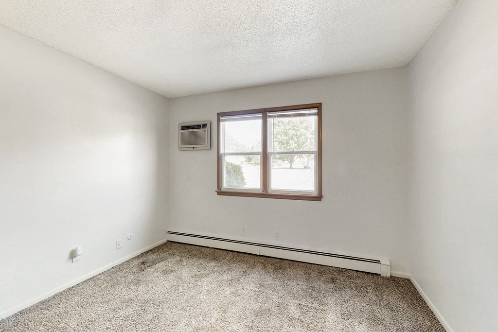 an empty room with white walls and a window