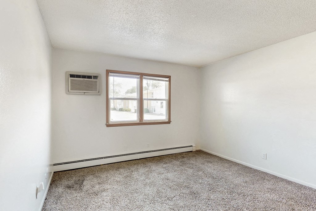 an empty room with carpet and a window