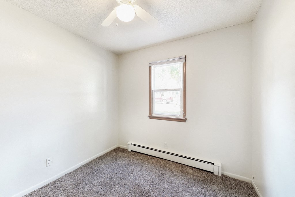 an empty room with white walls and a window