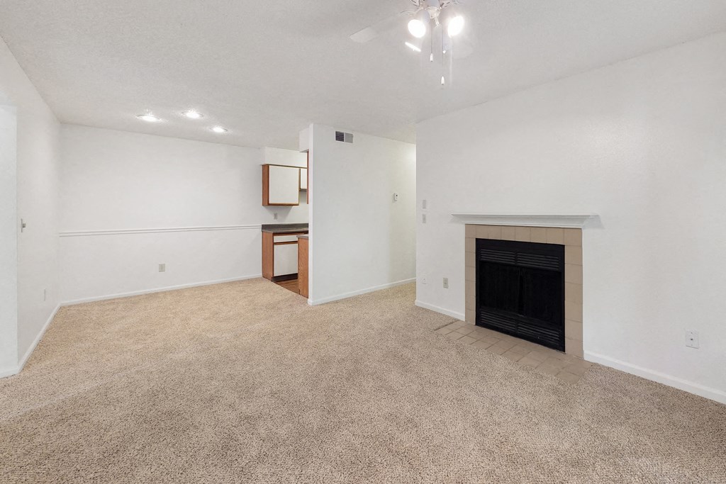 a living room with a fireplace and a carpeted floor