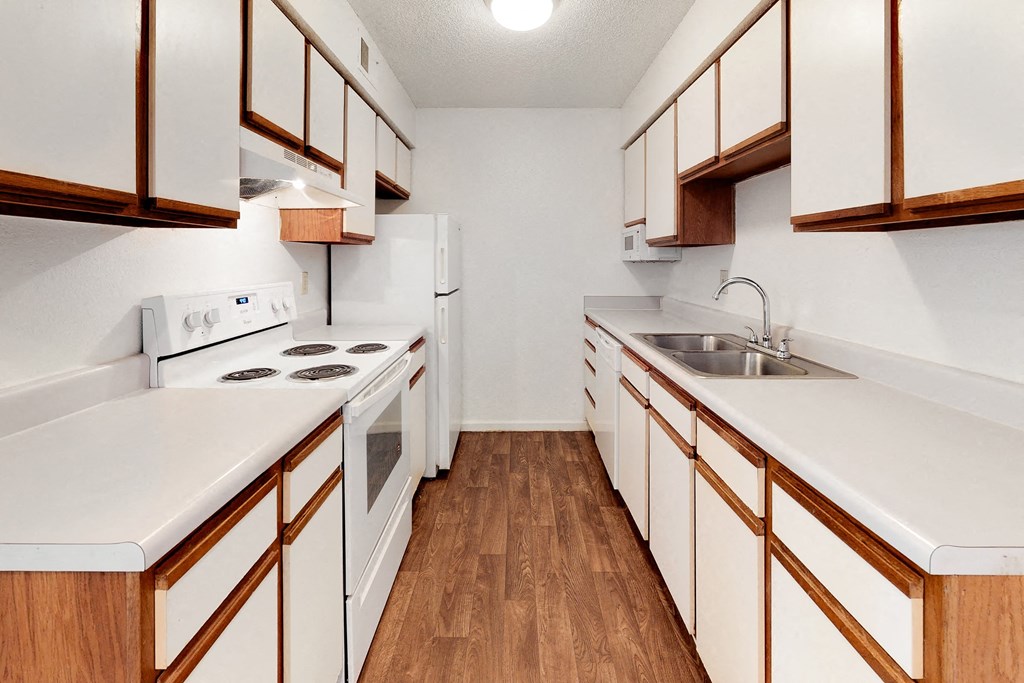 a kitchen with white appliances and wooden cabinets